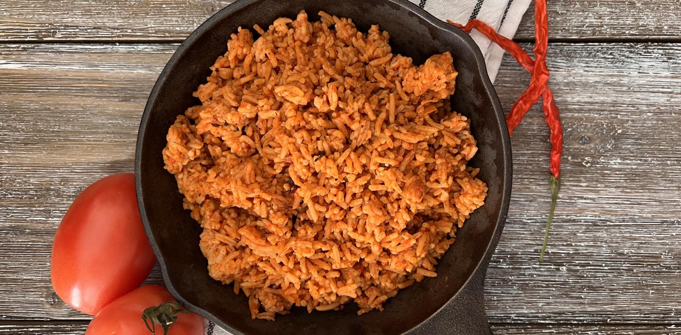 tomato-tinted cooked rice in a cast iron skillet