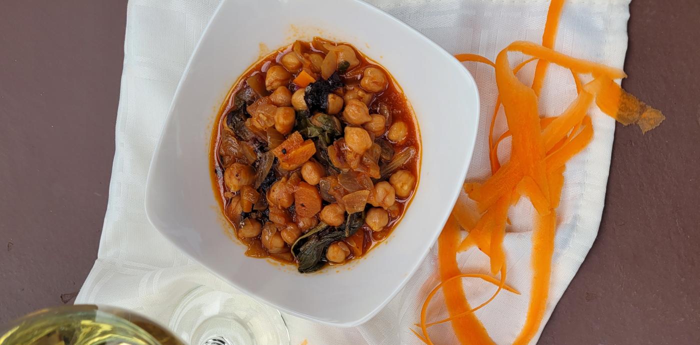 Chickpeas in a dish with a glass of wine