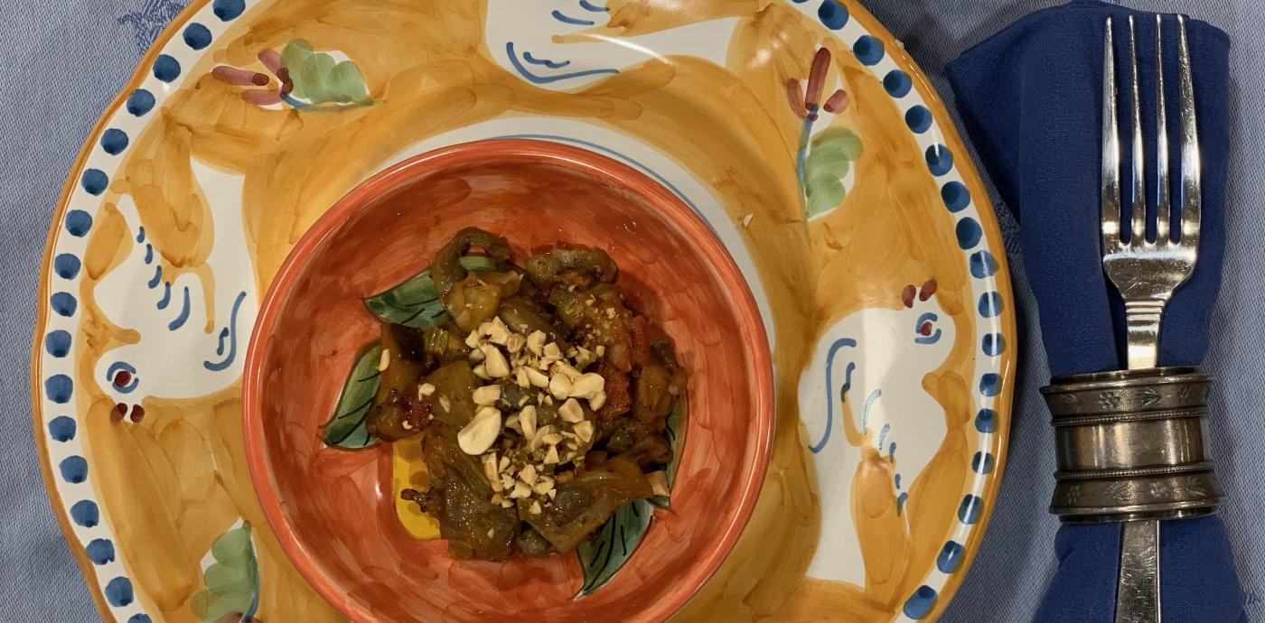Warm caponata with toasted peanuts on plate with side of peanuts