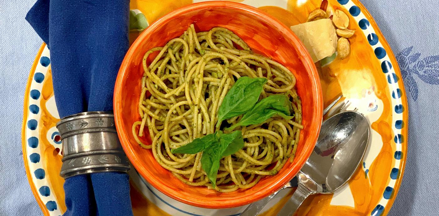 spaghetti with pesto sauce in an orange bowl