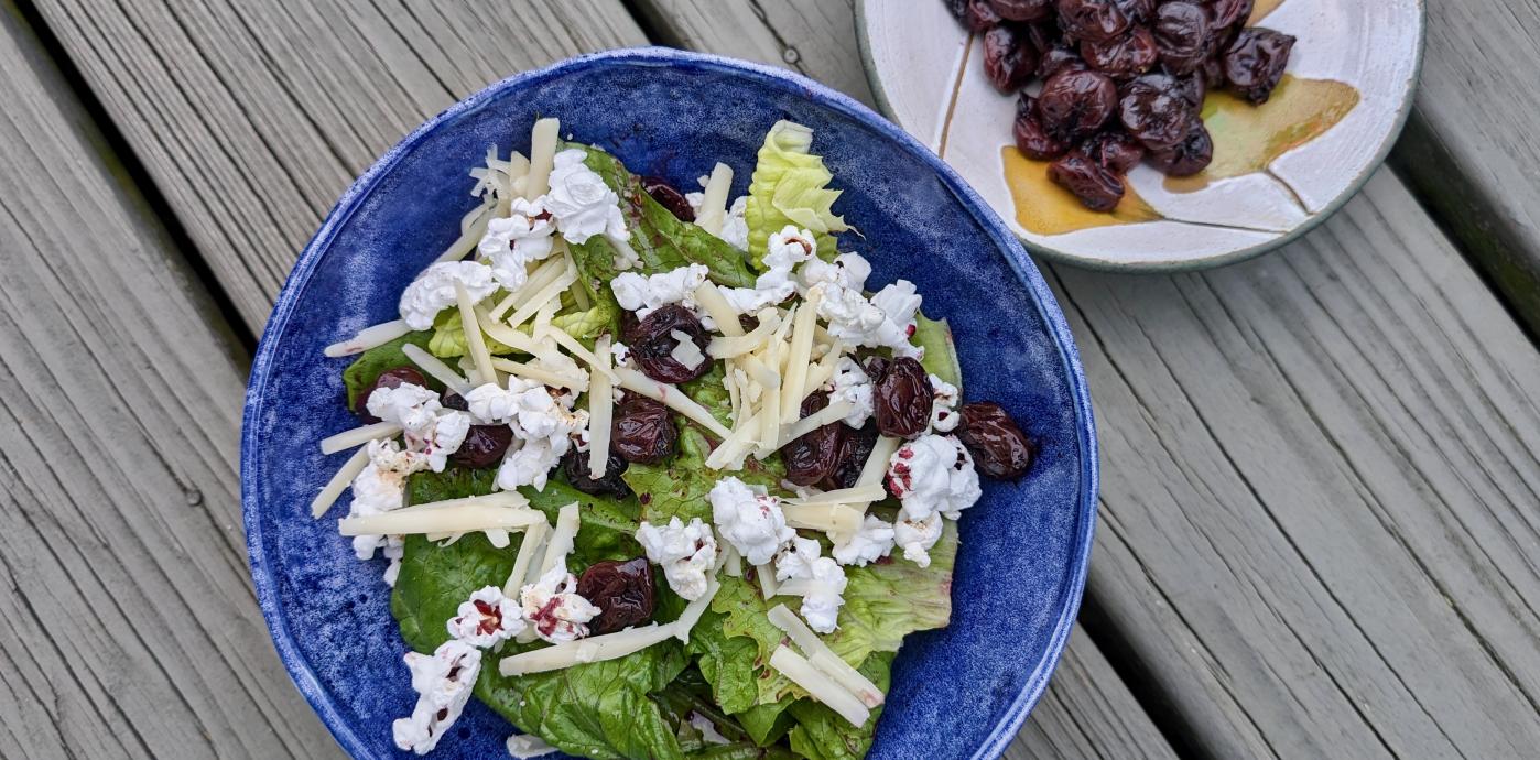 Big bowl with salad and small bowl with cherries