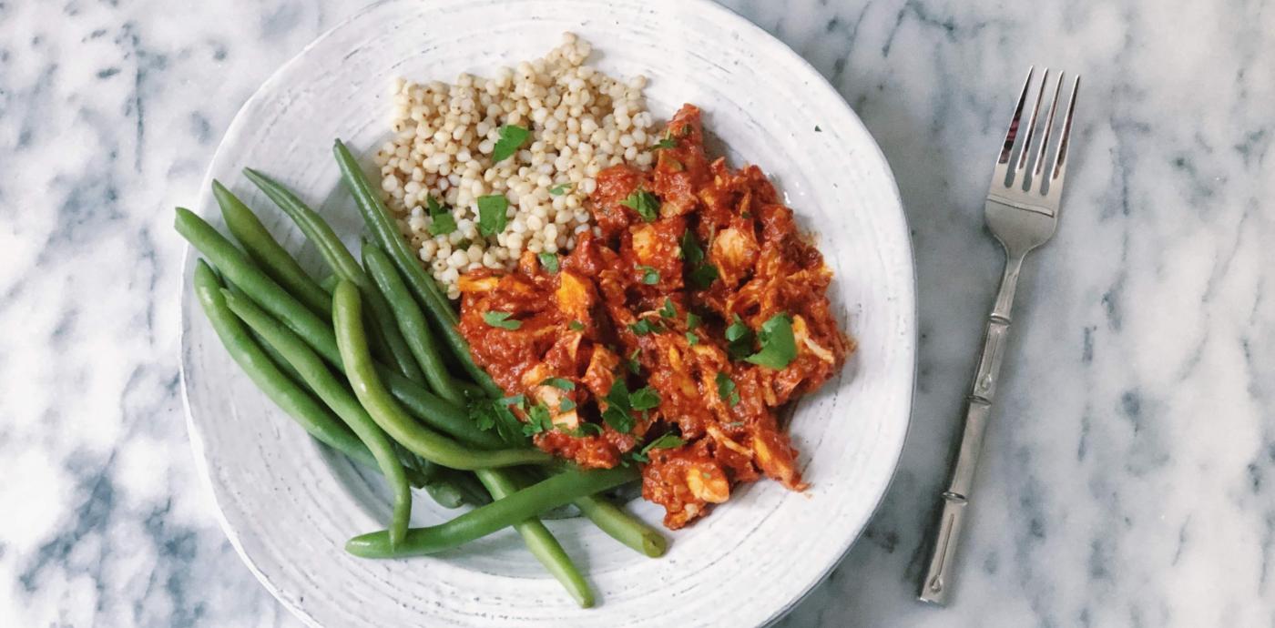chicken in romesco sauce served atop sorghum and green beans