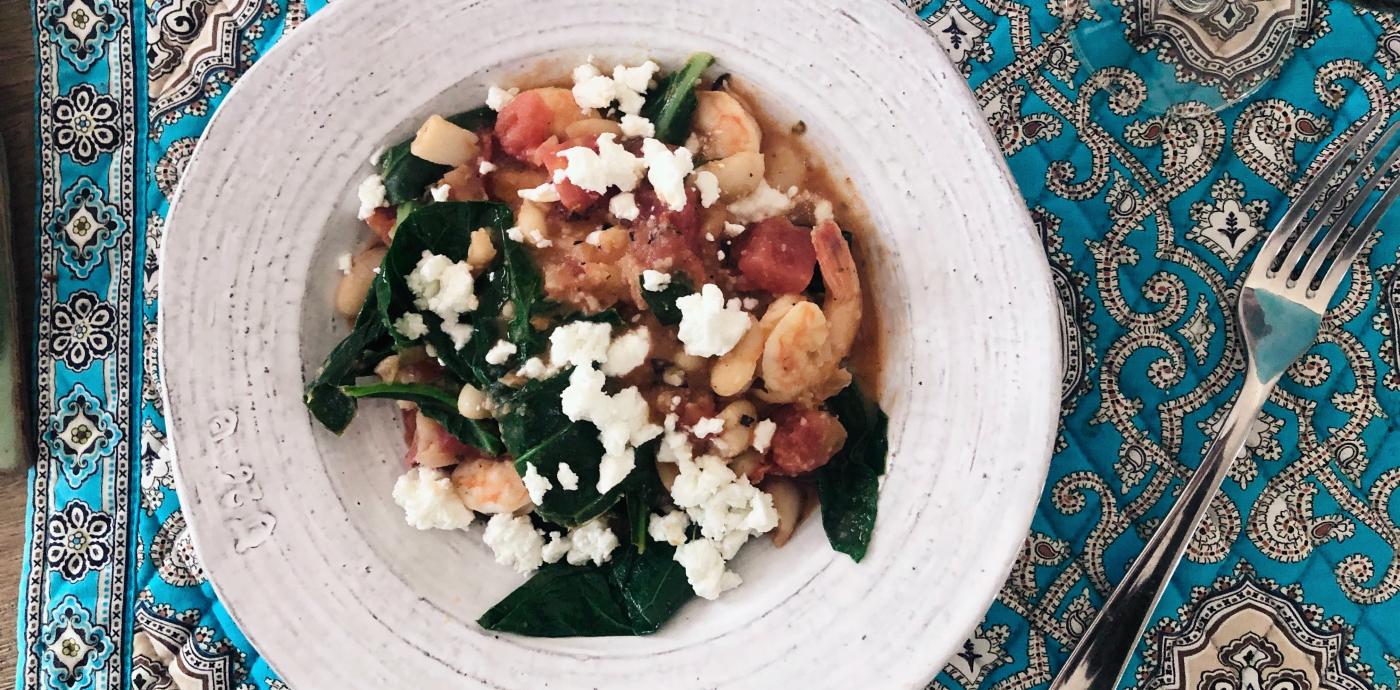 shrimp, greens, tomatoes, and feta in a bowl