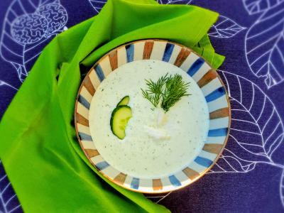 Bowl of white soup with cucumber and dill garnish