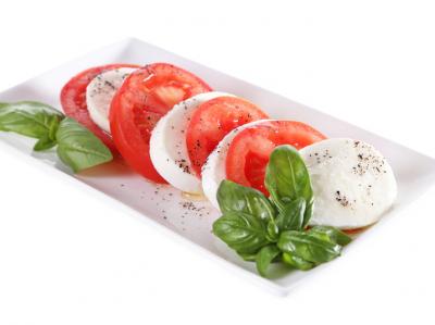 Plate of mozzarella cheese, tomatoes and basil