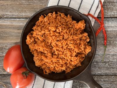 tomato-tinted cooked rice in a cast iron skillet