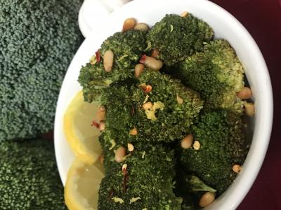 Broccoli in a dish with lemon and pine nuts