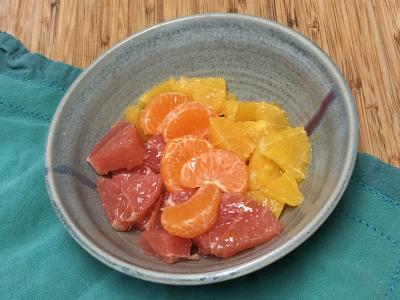 Mixed citrus slices in a bowl on a blue napkin