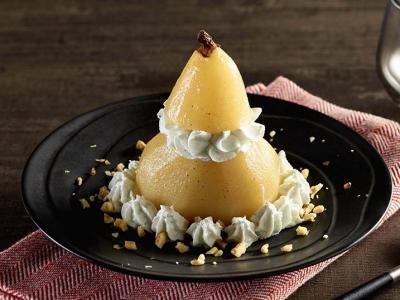 poached pear on a dark plate stuffed with elegantly piped Roquefort cream