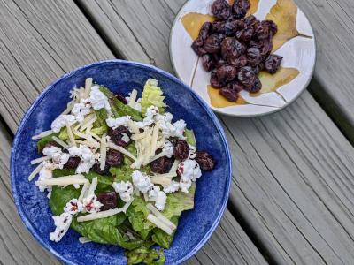 Big bowl with salad and small bowl with cherries