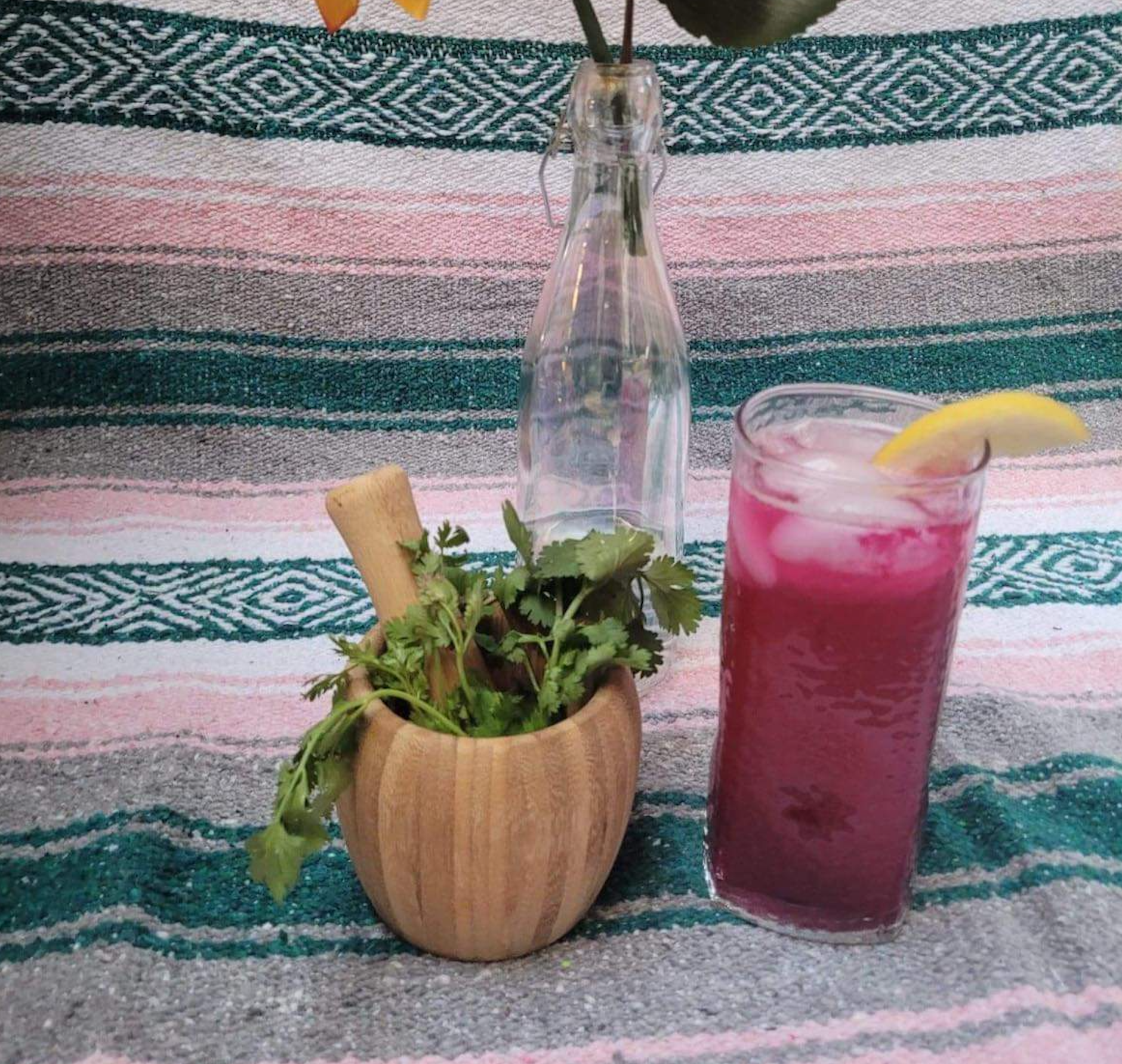 a vibrant magenta beverage in a glass set on a backdrop of patterned blankets