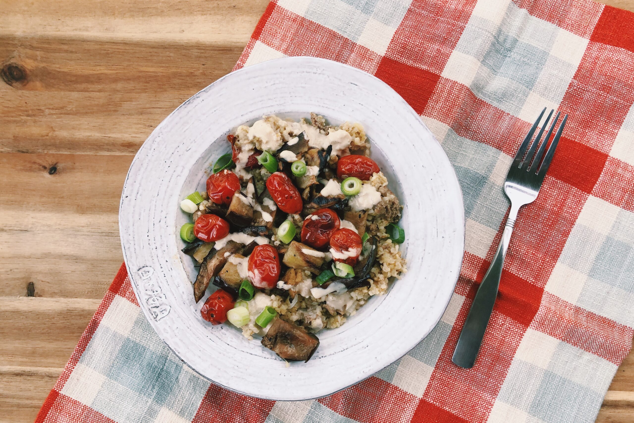 freekeh bowl with ground lamb, grilled tomatoes, and eggplant