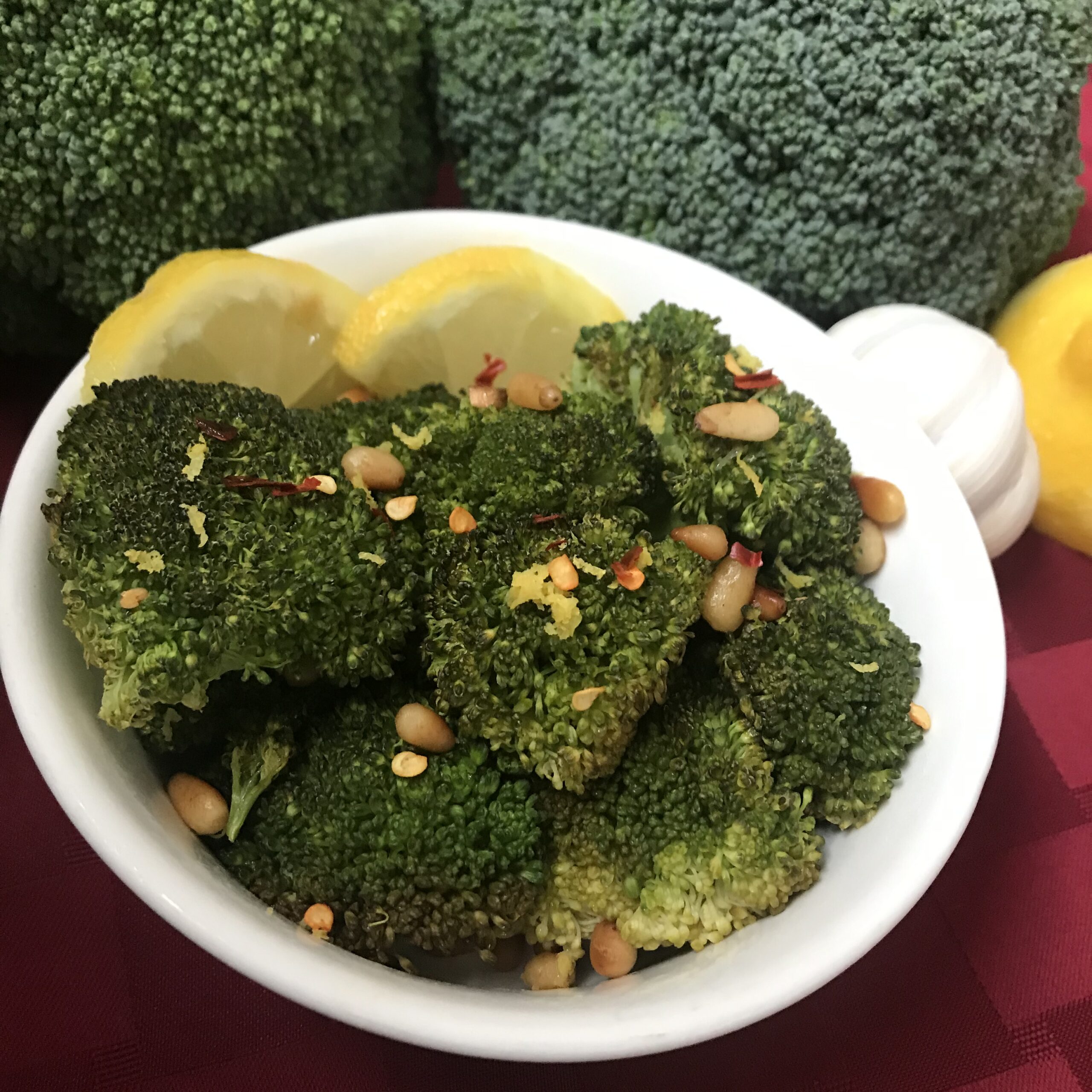 Broccoli in a dish with lemon and pine nuts