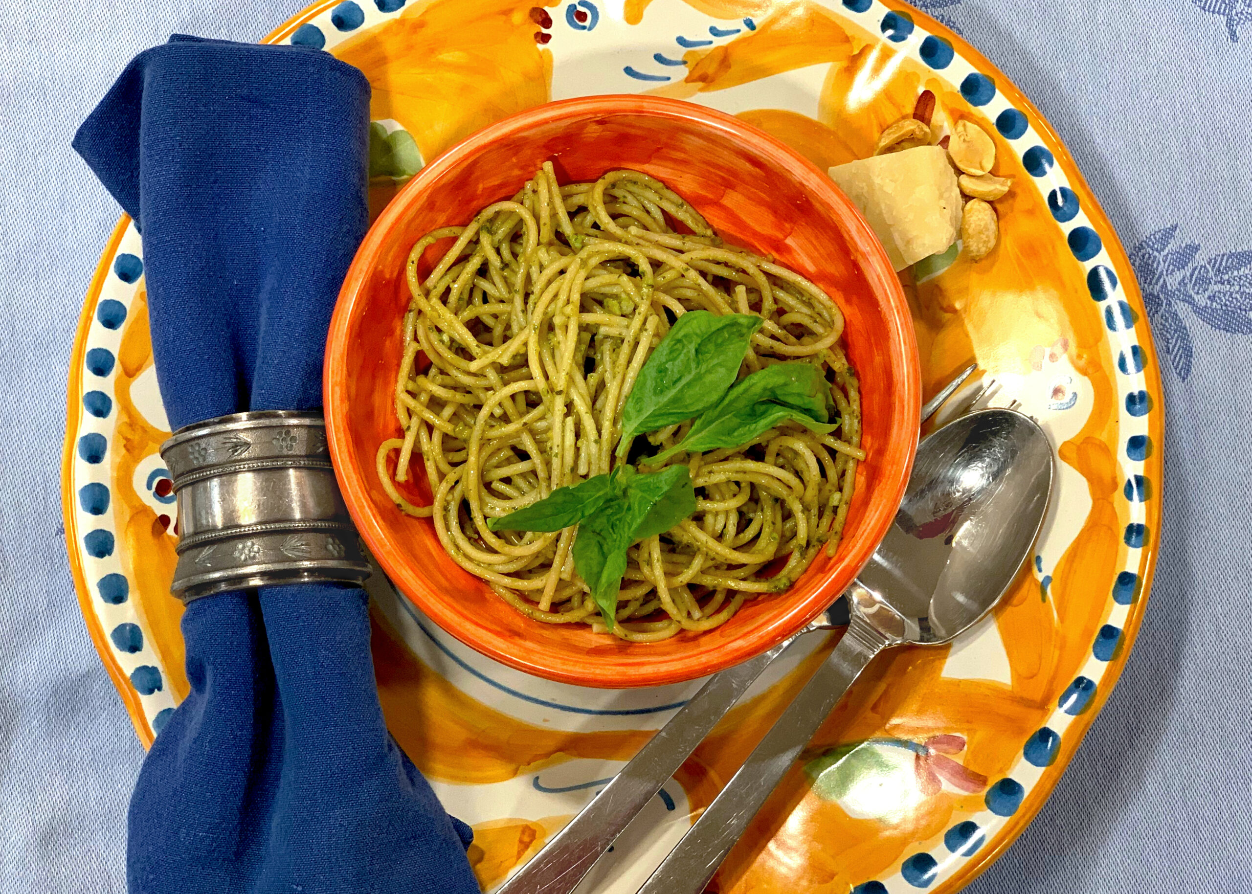 spaghetti with pesto sauce in an orange bowl