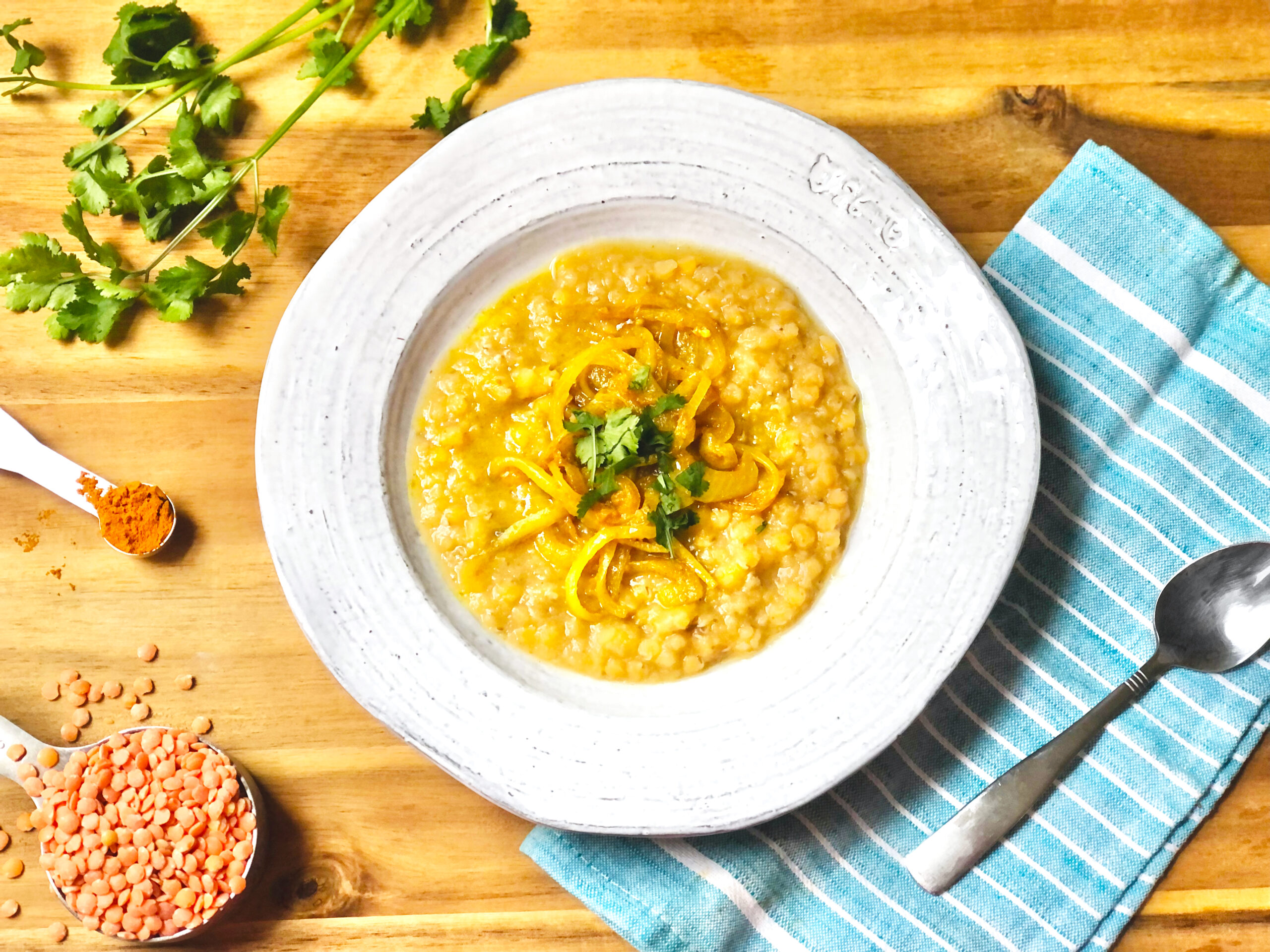 a red lentil soup in a white dish surrounded by the ingredients