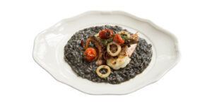 BLACK RISOTTO Croatian food served on white background