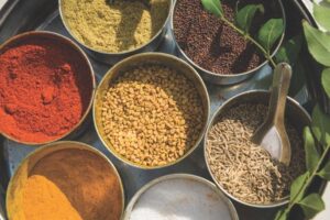 An assortment of spices displayed in metal bowls, highlighting diverse colors and forms.