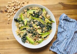 A delicious quinoa bowl topped with kale, avocado slices, and cashew pesto, representing a balanced and flavorful dish.