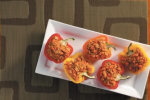 A white plate featuring five colorful stuffed peppers arranged neatly for an appetizing presentation.