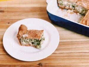 A plate with a slice of broccoli and cheese cake