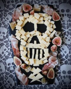 An artistic display of a skull formed from cheese and meat