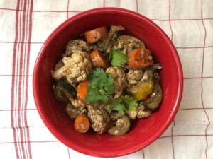 A bowl filled with fresh vegetables, topped with a spoon, showcasing a healthy and colorful meal option.