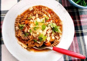 A bowl of pasta mixed with colorful vegetables