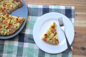 A slice of quiche placed on a white plate