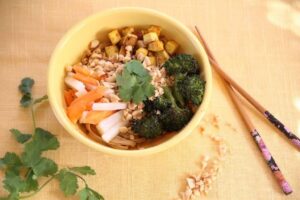 A bowl of assorted vegetables accompanied by chopsticks, highlighting a nutritious and appetizing dish.