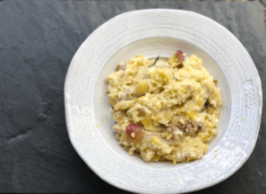 A white plate featuring a serving of rice accompanied by tender pieces of meat, elegantly arranged for a meal.