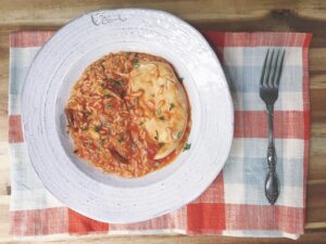 A plate featuring a bowl of food and a fork placed beside it