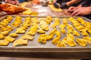 A tray filled with various pasta dishes is being prepared for an upcoming party event.