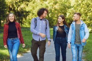 Four young friends walking side by side in a park