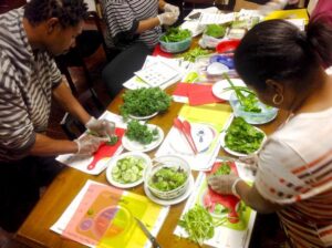 A diverse group of people collaboratively preparing food on a table