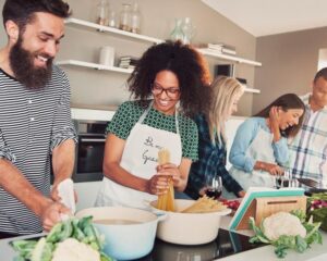 A diverse group of people cooking together in a bright kitchen