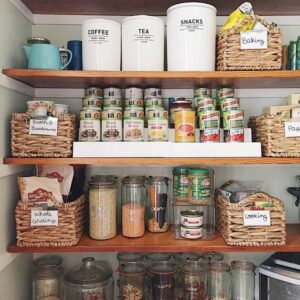 A pantry featuring organized shelves and baskets filled with various food items.