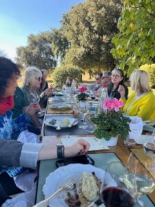 A group of women enjoying a meal and wine together at a table
