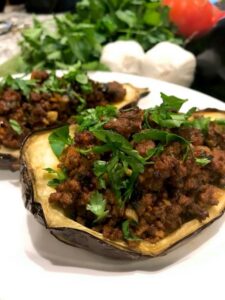 A plate featuring two halves of stuffed eggplant
