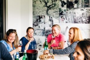 A group of people enjoying wine while seated around a table