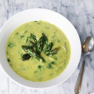 Creamy green asparagus soup with a slice of lemon garnish