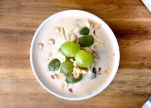 a creamy dish topped with green grapes and peanuts