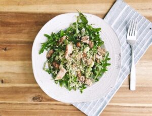 A delicious salad with tender chicken, leafy greens, and a mix of nuts
