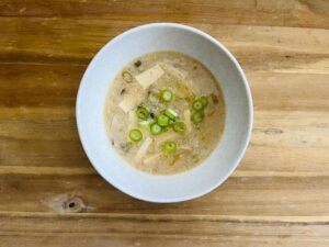 A bowl of soup garnished with chopped green onions